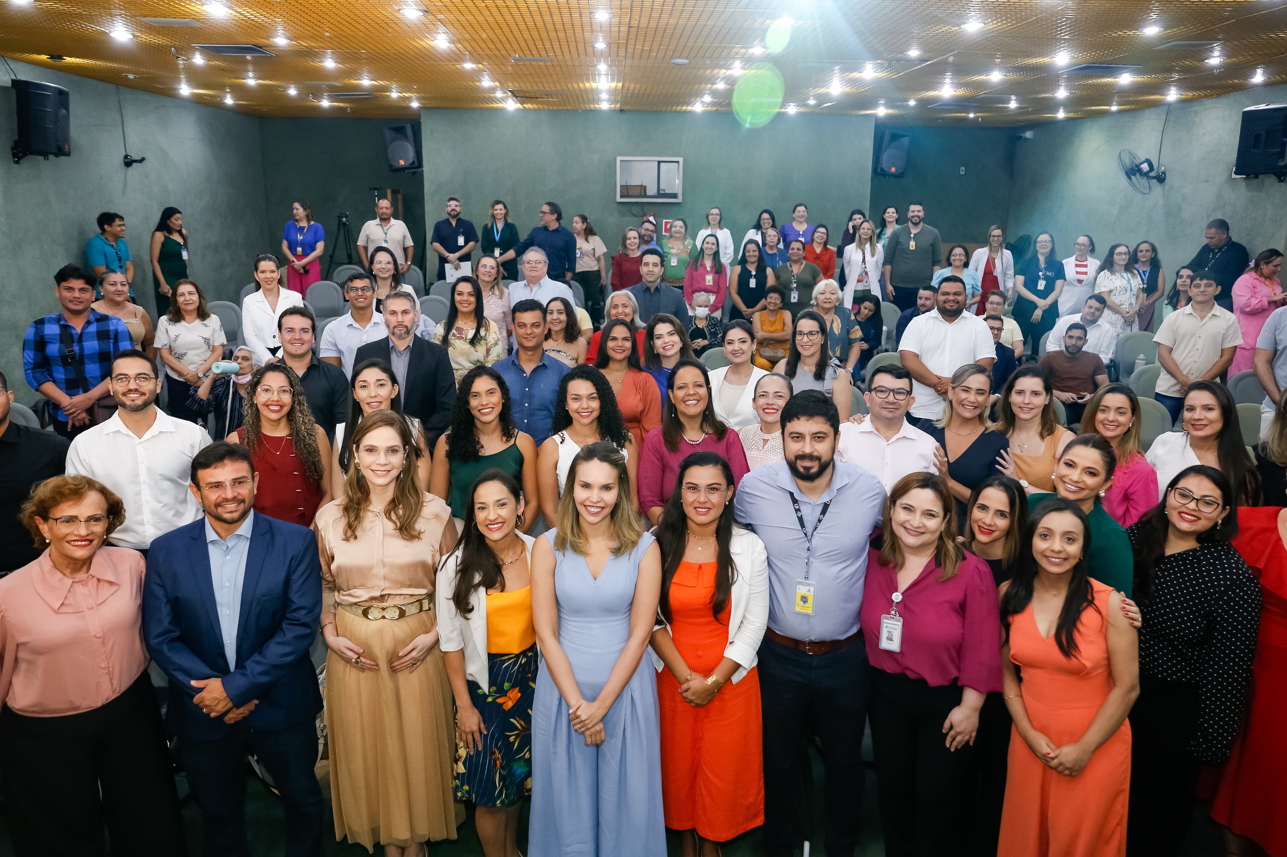 grupo de pessoas posa para a foto no auditório do IJF